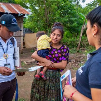Funcionarios del gobierno y de WFP conversan con una madre de familia.